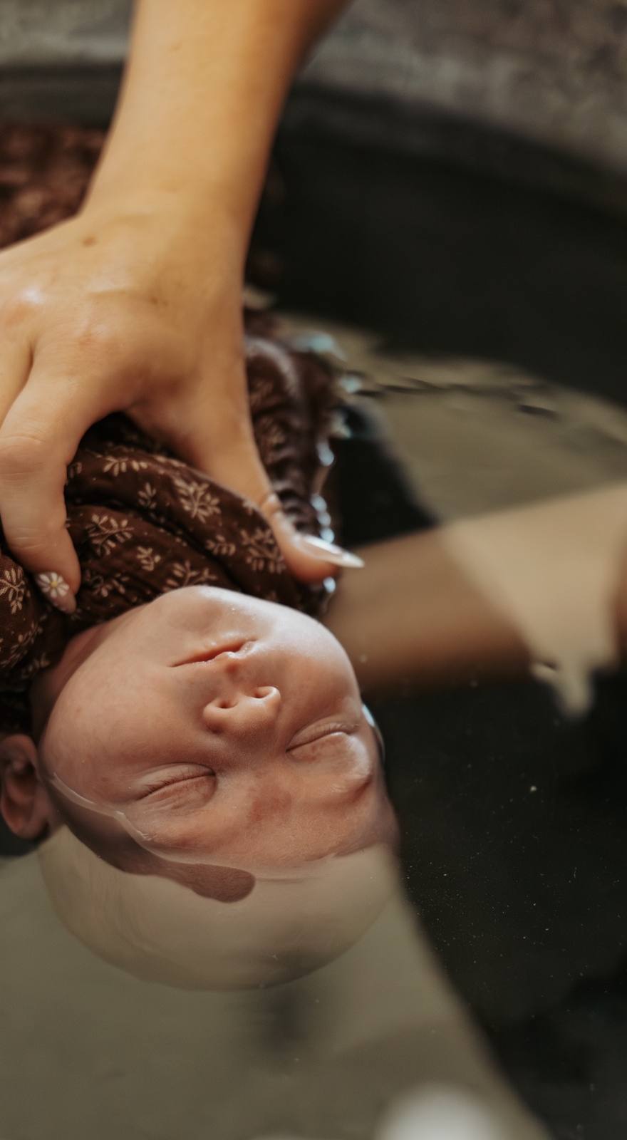 Regard complice entre une mère et son nouveau-né pendant un bain sensoriel, accompagnés par Marine Eloy